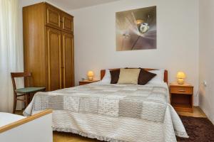 ein Schlafzimmer mit einem Bett und zwei Nachttischen und zwei Lampen in der Unterkunft Holiday house with a parking space Veli Rat, Dugi otok - 8096 in Veli Rat