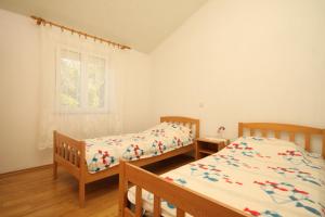 a bedroom with two beds and a window at Apartments by the sea Luka, Dugi otok - 8151 in Luka
