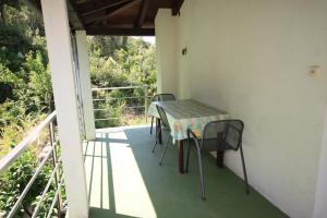 uma mesa e cadeiras na varanda de uma casa em Apartments by the sea Luka, Dugi otok - 8151 em Luka
