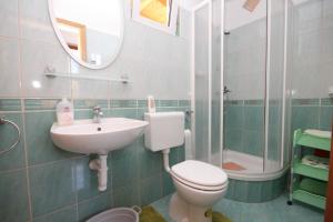 łazienka z toaletą, umywalką i lustrem w obiekcie Apartments with a parking space Sali, Dugi otok - 8153 w mieście Sali