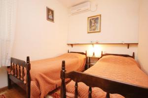 two beds sitting next to each other in a bedroom at Family friendly apartments with a swimming pool Okrug Donji, Ciovo - 8072 in Okrug Donji