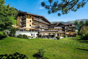 een groot gebouw met een gazon ervoor bij Brugger's Genießerhotel Lanersbacherhof in Tux