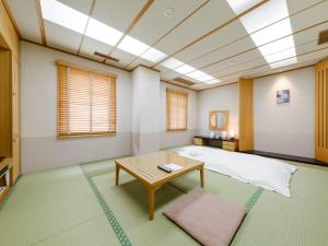 网走市Tabist Abashiri Central Hotel的配有床和桌子的房间