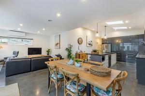 a kitchen and living room with a wooden table and chairs at Dianas Place in Warrnambool