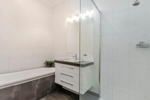 a white bathroom with a sink and a shower at Dianas Place in Warrnambool