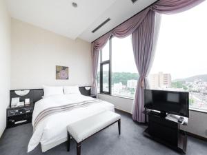 a bedroom with a bed and a flat screen tv at Tabist Abashiri Central Hotel in Abashiri