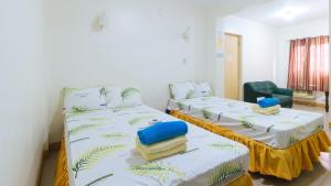 Cette chambre comprend deux lits et une chaise. dans l'établissement Golden Sunrise Hotel I by RedDoorz, 