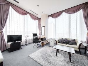 a living room with a couch and a tv at Tabist Abashiri Central Hotel in Abashiri