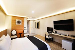 Habitación de hotel con cama y TV de pantalla plana. en Buan Tourist Hotel en Buan