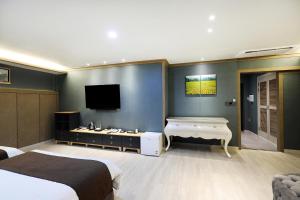 a bedroom with two beds and a flat screen tv at Buan Tourist Hotel in Buan