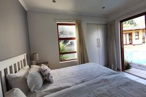 Un dormitorio con una cama grande y una ventana en Somona Guest House, en Johannesburgo