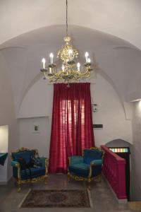 Zimmer mit zwei blauen Stühlen und einem Kronleuchter in der Unterkunft Le Fate Ignoranti in Mesagne