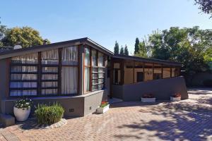 una casa con muchas ventanas y macetas en Somona Guest House, en Johannesburgo