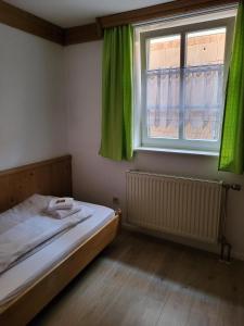 a bedroom with a bed and a window with green curtains at Historik Hotel Ochsen in Tamm