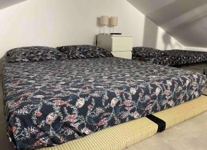 una camera da letto con un letto con una coperta a fiori di Petit Fare Rochois avec mezzanine a La Roche-des-Arnauds