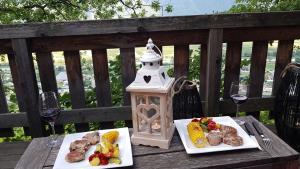 einen Tisch mit zwei Teller Essen und Gläsern Wein in der Unterkunft La Terrasse in Fully