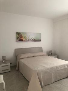 a bedroom with a bed and a painting on the wall at Casa Sofia in Marconia