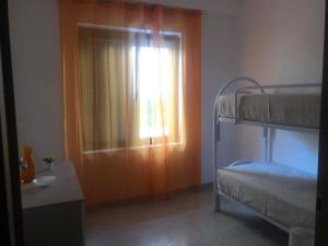 a bedroom with a window and a bunk bed at Casa Sofia in Marconia