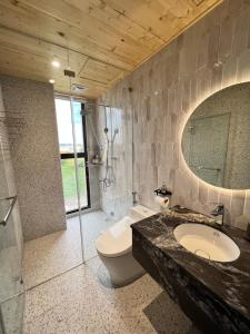a bathroom with a sink and a toilet and a mirror at Lin House in Checheng