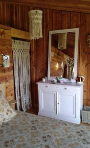 a bedroom with a white dresser and a mirror at Domaine de Sault in Dore-lʼÉglise