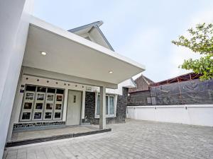 a white house with a driveway and a garage at SUPER OYO 91618 Hotel Nawangwulan in Blitar