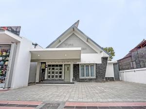 a white house with a driveway in front of it at SUPER OYO 91618 Hotel Nawangwulan in Blitar