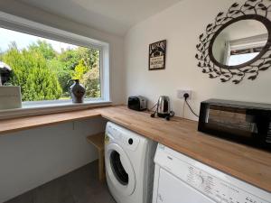 a kitchen with a counter with a microwave and a window at Three. bedroom detached houes in St .AIbans city in St. Albans