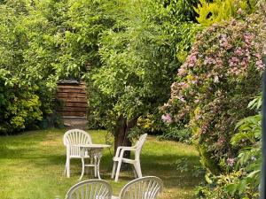 two white chairs and a table in a garden at Three. bedroom detached houes in St .AIbans city in St. Albans