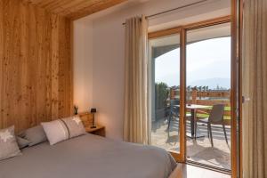 a bedroom with a bed and a balcony with a table at Agritur Maso Librar in Trento