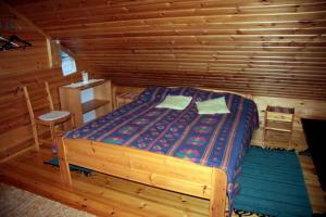 ein Schlafzimmer mit einem Bett in einem Blockhaus in der Unterkunft Pohjantilan Hirsituvat - Pohjantähti in Kontiolahti