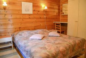 um quarto com uma cama com duas almofadas em Pohjantilan Hirsituvat - Pohjantähti em Kontiolahti