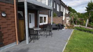 un patio avec des chaises et une table à côté d'un bâtiment dans l'établissement Glockenturmblick, à Sankt-Andreasberg