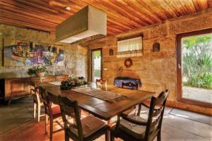 une salle à manger avec une table en bois et une cheminée dans l'établissement Casa da Alvarinha Privada rodeada de Natureza, à Paredes