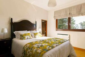 a bedroom with a large bed with a floral blanket at Casa da Alvarinha Privada rodeada de Natureza in Paredes