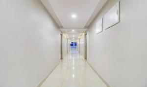 an empty corridor of a hospital hallway with white walls and white tile floors at Treebo Grand Milan in Visakhapatnam