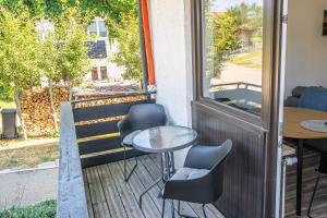 einen Balkon mit Stühlen, einem Tisch und einem Fenster in der Unterkunft Kleine Heimat in Ofterschwang