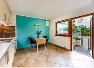 a kitchen with blue walls and a table and chairs at bergRESORT apartments in Děčín