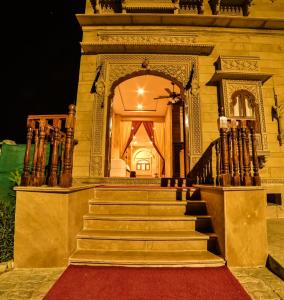 a staircase leading to a building with a red carpet at The Bheemgarh in Jaisalmer