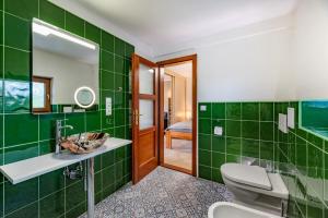 a green bathroom with a toilet and a sink at bergRESORT apartments in Děčín
