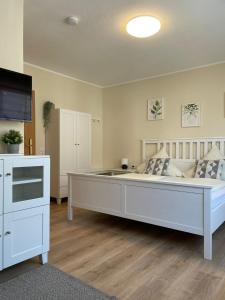 Cama blanca grande en habitación con suelo de madera en Gasthaus Stammbaum, en Andernach