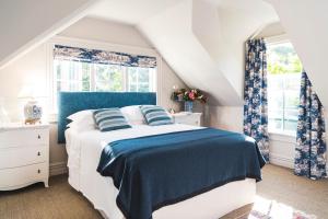 a bedroom with a blue and white bed and windows at Ranginui Retreat in Masterton