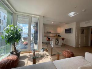 a living room with a couch and a large window at Exclusive apartment, sea view to Oslo fjord, located on water in Oslo center in Oslo