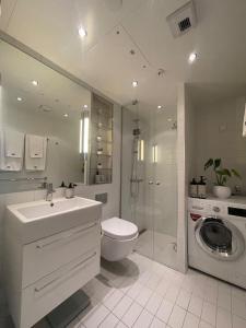 a bathroom with a toilet sink and a washing machine at Exclusive apartment, sea view to Oslo fjord, located on water in Oslo center in Oslo