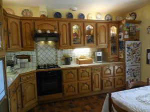 eine Küche mit Holzschränken und einem Kühlschrank in der Unterkunft La Madriguera Accommodation in Gardes-le-Pontaroux