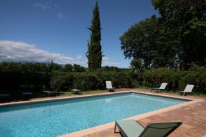 a swimming pool with two chairs and a table at Château de Saü in Thuir