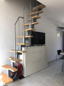 a spiral staircase in a living room with a tv at Apartman Valinor in Miholašćica