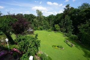 een uitzicht over de tuin met banken en bloemen bij Landhaus am Rehwald in Donzdorf