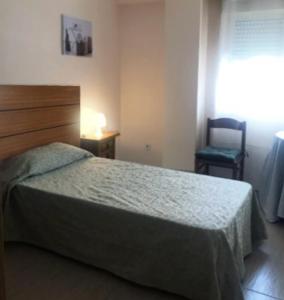 1 dormitorio con 1 cama y 1 silla en Victoria Hospedaje, en Alicante