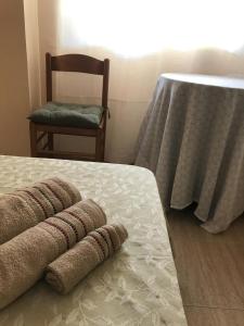 a room with a bed with a chair and a table at Victoria Hospedaje in Alicante