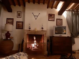 a living room with a fireplace and a tv at Villa Saturnia in Saturnia
